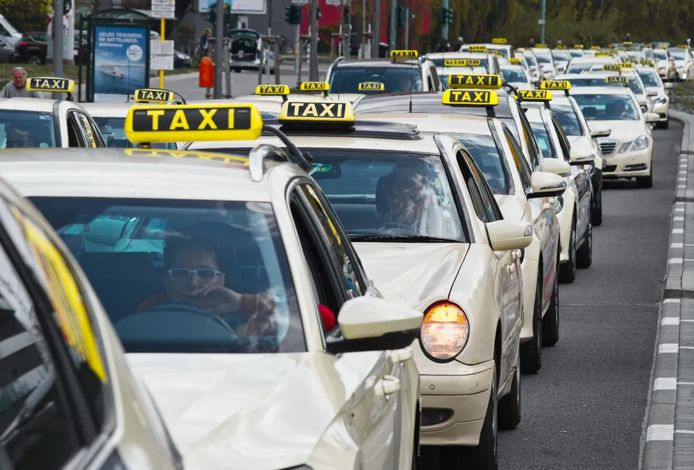 Line of taxis with roof signs queuing on a city street
